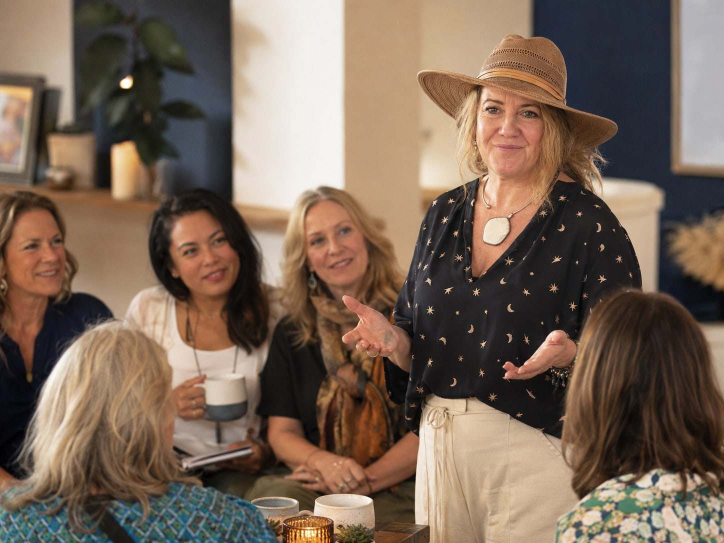 Jules leading a small-group coaching conversation with women holding cups of tea