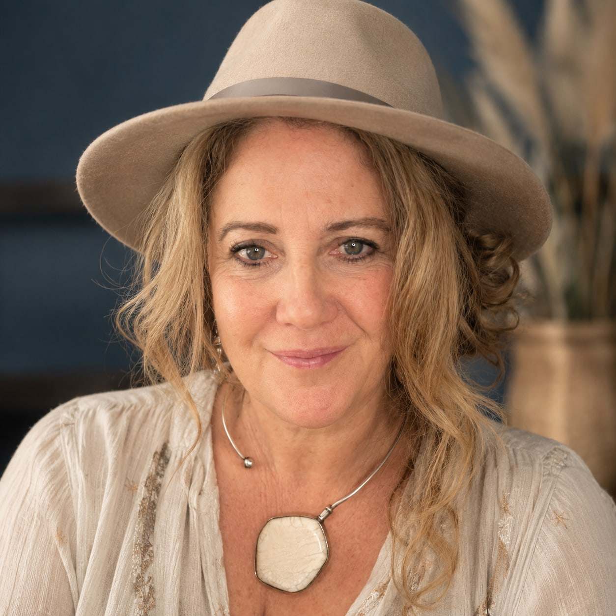 Portrait of Jules Wheeler, transformational coach, in a wide-brimmed hat