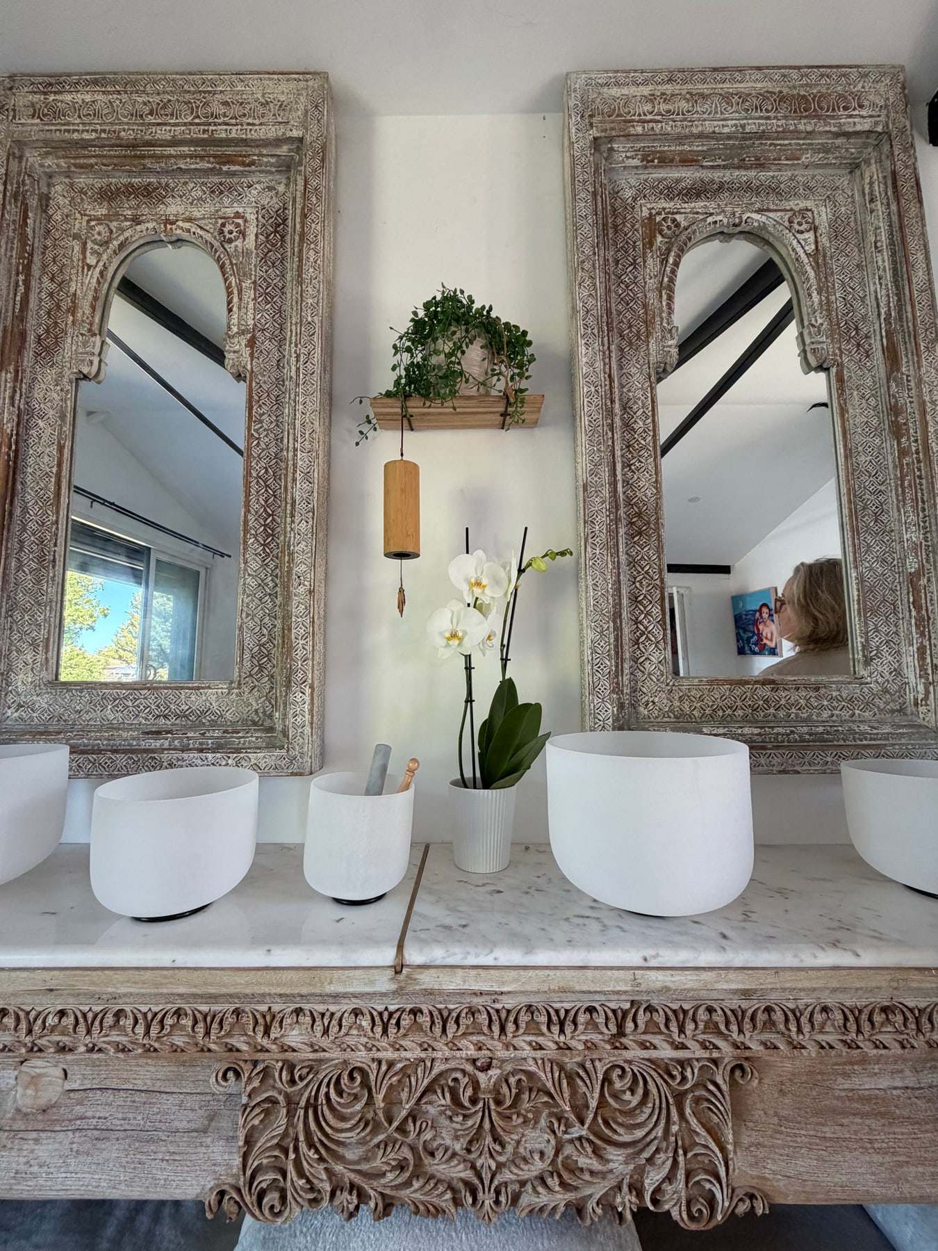 Crystal singing bowls beneath carved timber mirrors at The Confidence Studio, Ocean Grove
